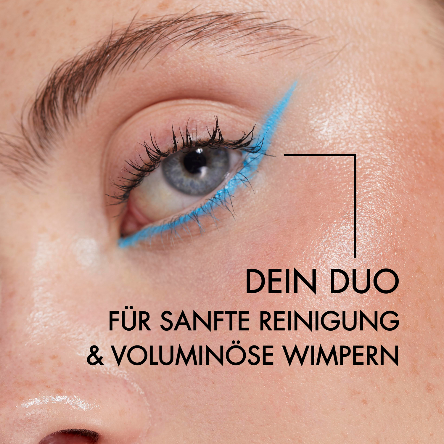 Nahaufnahme eines mit blauem Lidstrich geschminktem Auge einer jungen Frau. Neben ihrem Gesicht steht in schwarzer Schrift: "Dein Duo für sanfte Reinigung und voluminöse Wimpern"