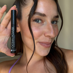 Portrait einer jungen Frau die das Ocean Power Wimpernserum in der Hand hält. 