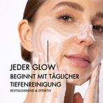 Nahaufnahme einer Frau mit Reinigungsschaum im Gesicht. Neben ihrem Gesicht steht in schwarzer Schrift: "Jeder Glow beginn mit täglicher Tiefenreinigung. Revitalisierend & effektiv"