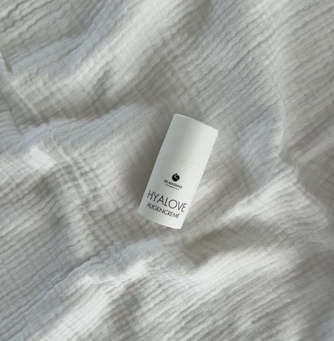 Produkt Bild Detail Aufnahme von Hyalove Augencreme auf einem weißen Bettlaken liegend für Abendroutine