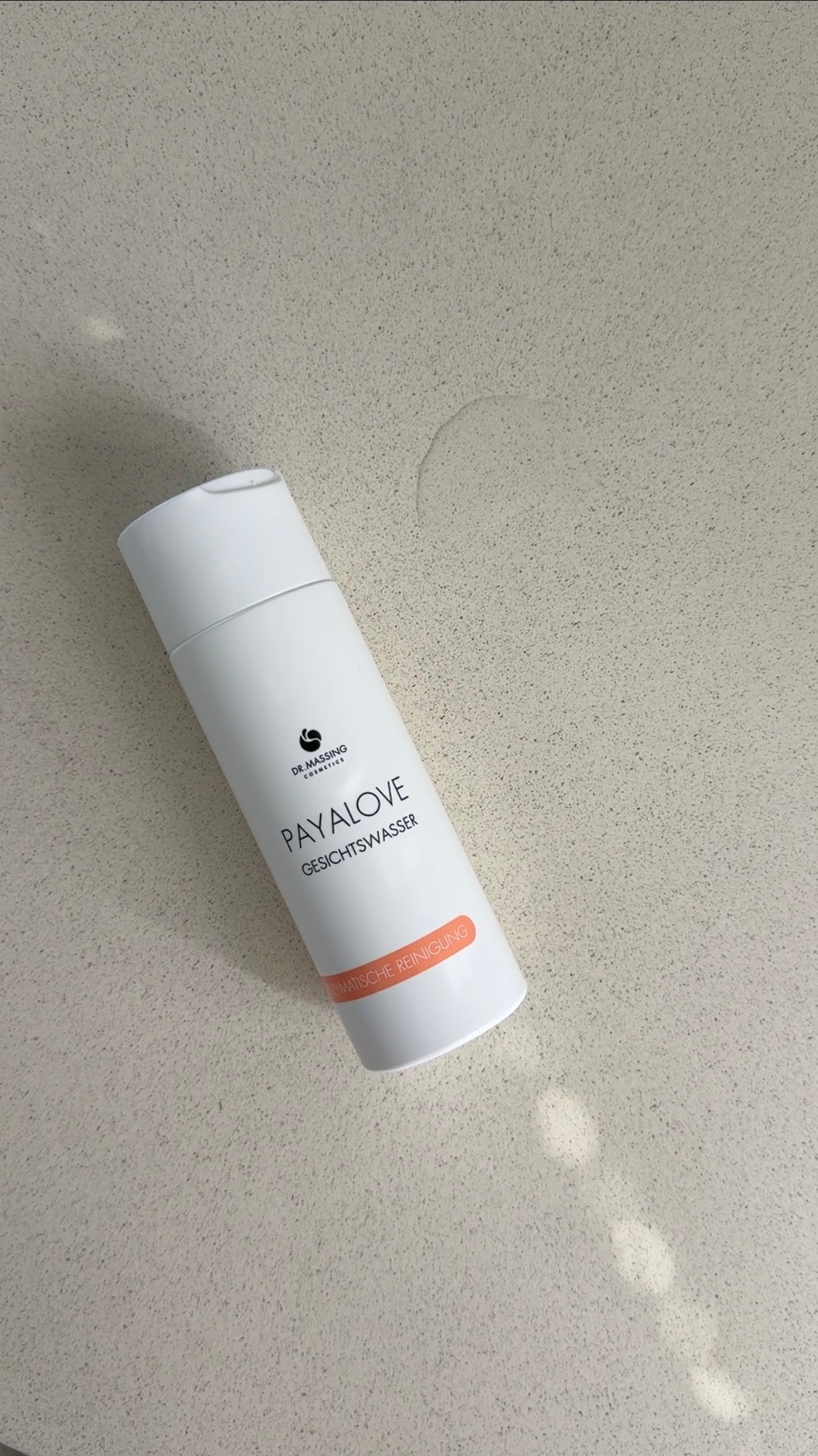 Payalove Gesichtswasser mit Textur liegt auf sandfarbenen Tisch