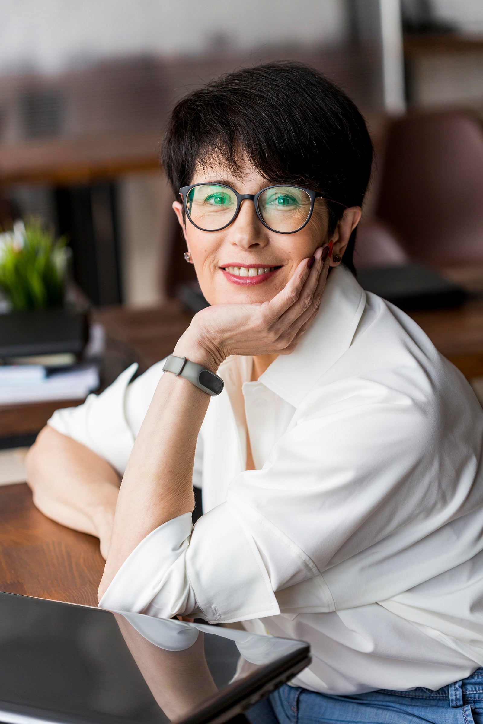 Portrait einer Frau mit Brille. Sie hat gepflegte Gesichtshaut und kurze voluminöse Haare.