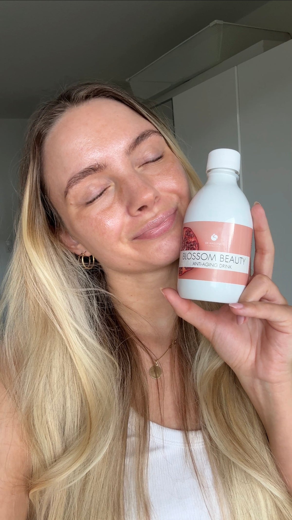 Frau hält Beauty Drink in der Hand neben ihr Gesicht