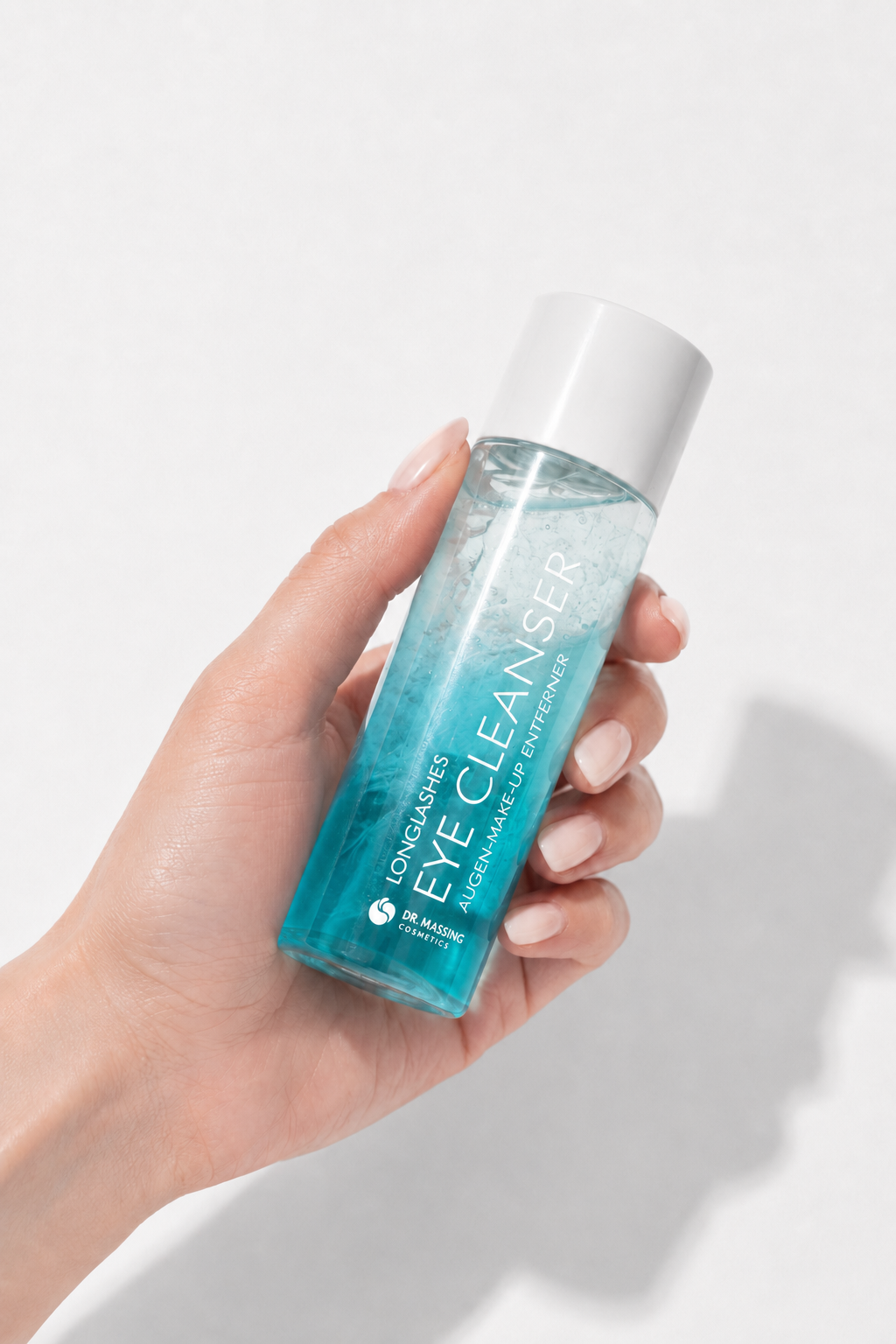 Eine Hand die dien Eye Cleanser von Dr. Massing schüttelt, damit sich beide Phasen verbinden