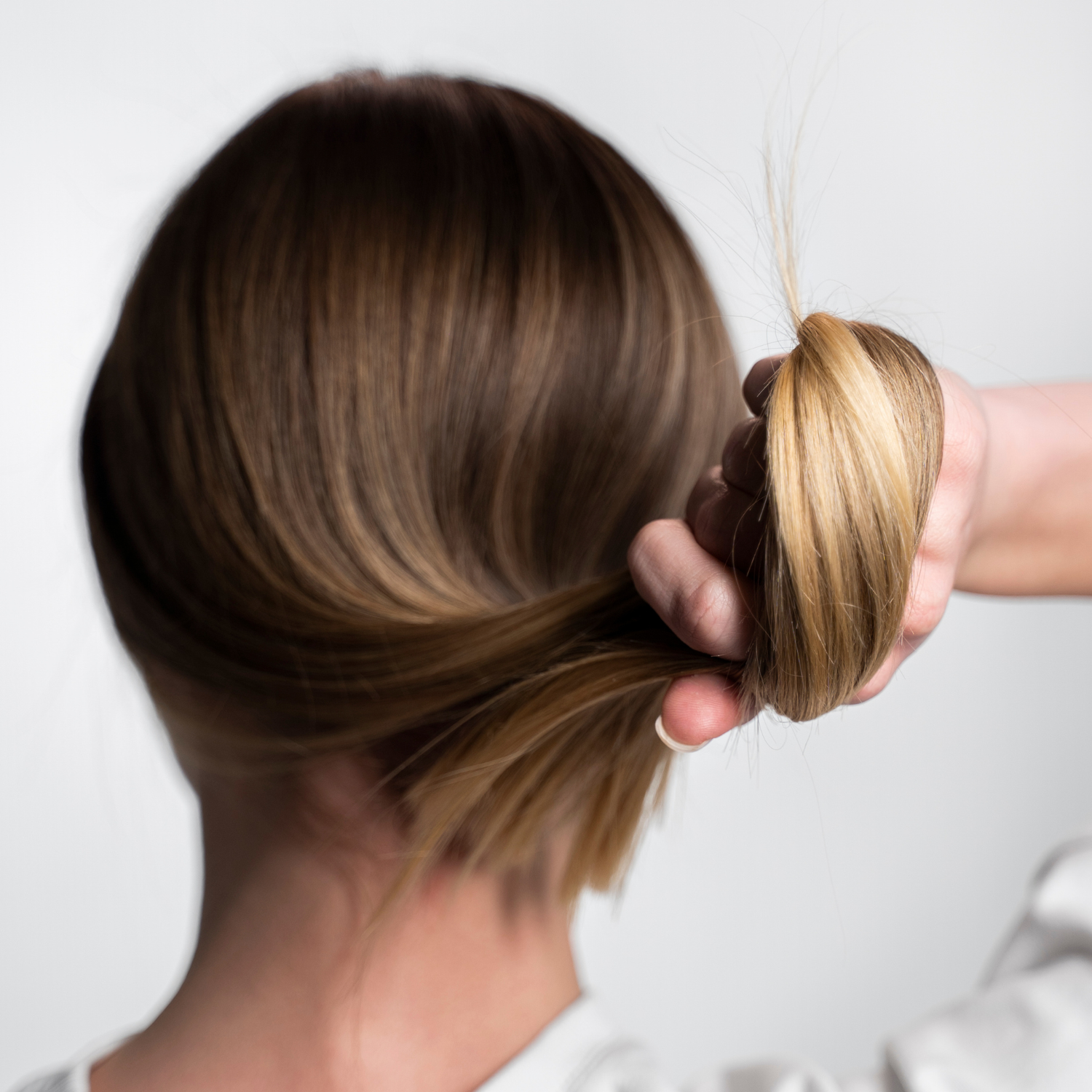 Eine Frau hält ihr kräftiges Haar in der Hand