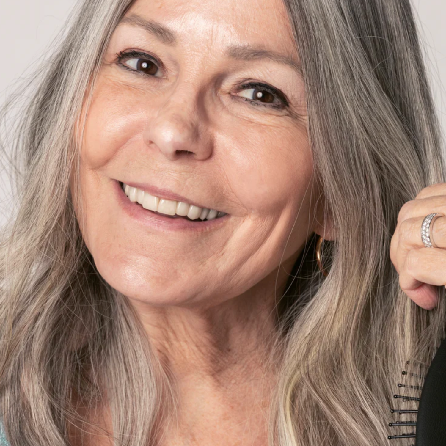 Portrait einer lächelndenden Frau mit langen grauen Haaren