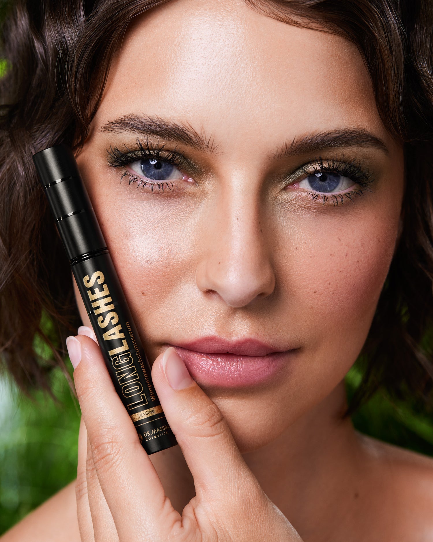 Nahaufnahme einer Frau die Long Lashes Sensitive präsentiert vor natürlichem Hintergrund