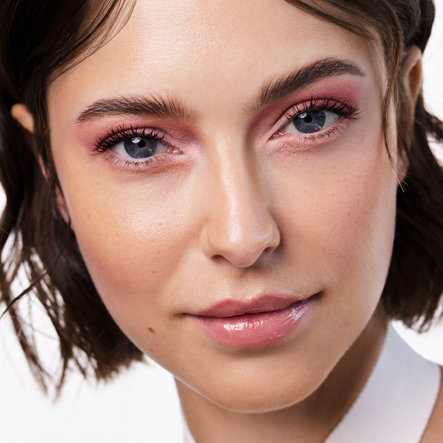 Nahaufnahme einer jungen Frau die ausdrucksstarkes Augen Make-up trägt und schöne lange Wimpern hat
