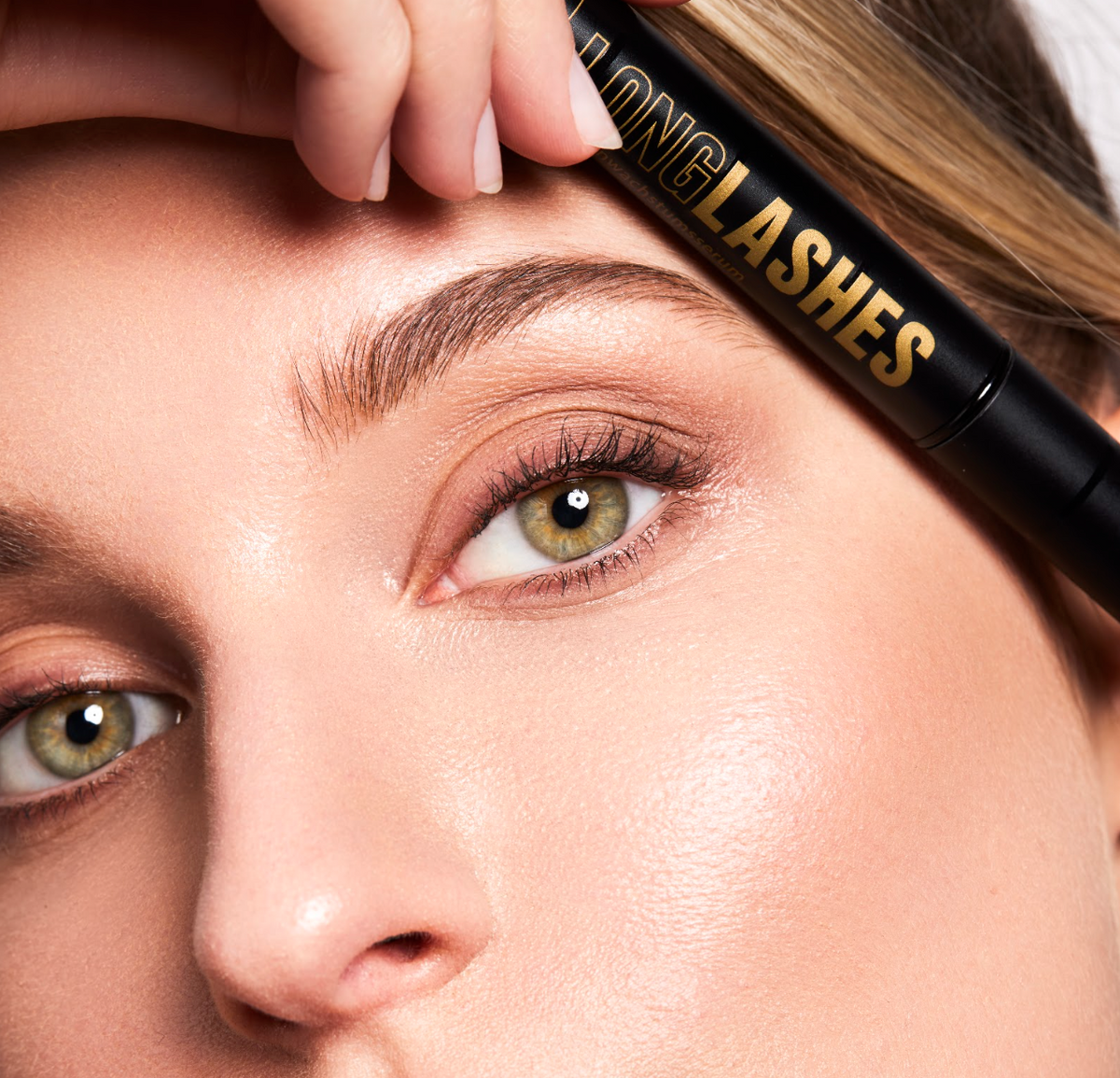 Nahaufnahme einer Frau die Long Lashes Classic an ihre Stirn über den langen Wimpern hält