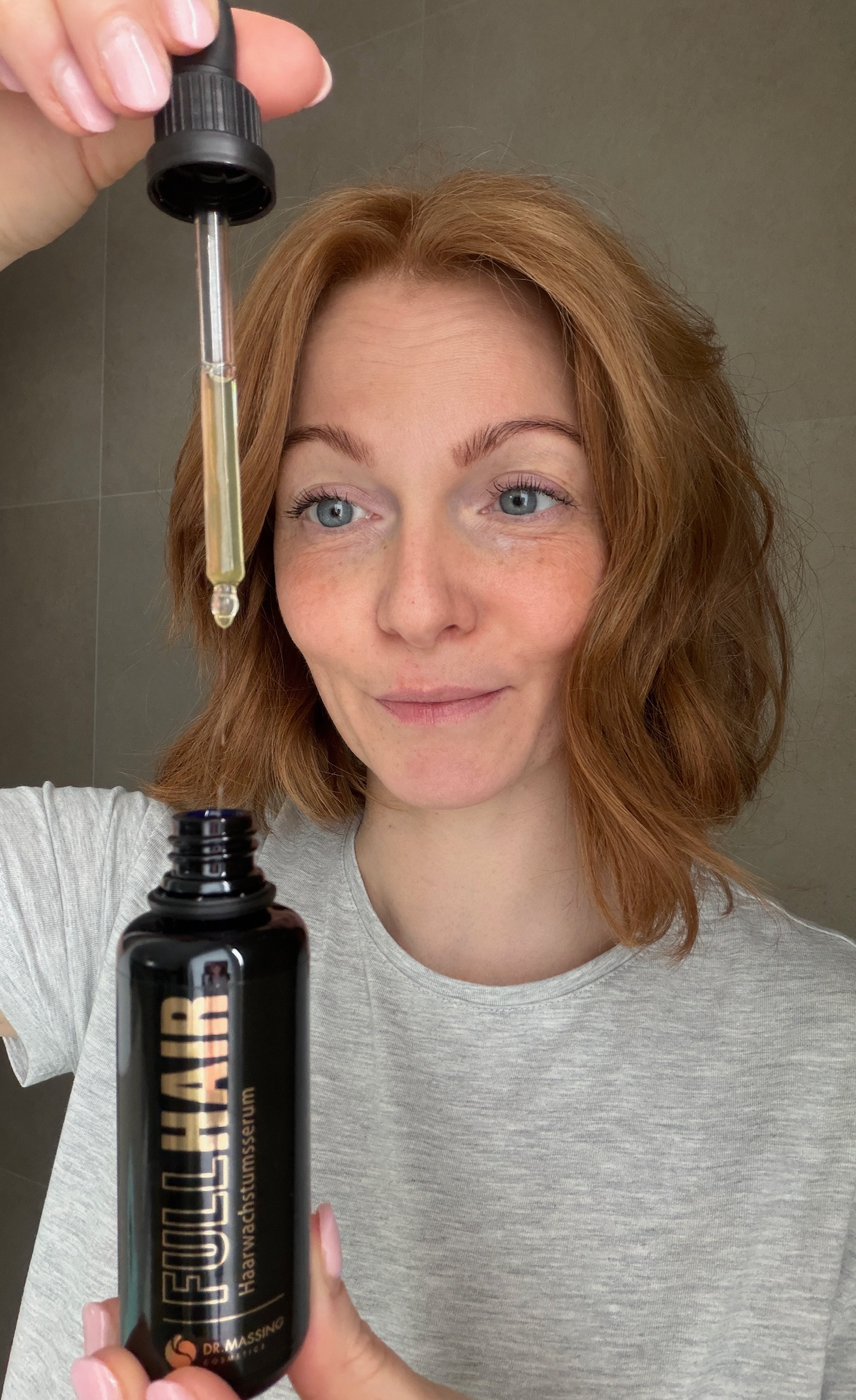 3. Schritt der Anwendung Haarwuchsmittel bei dem Serum mit Pipette aus der Flasche herausgezogen wird