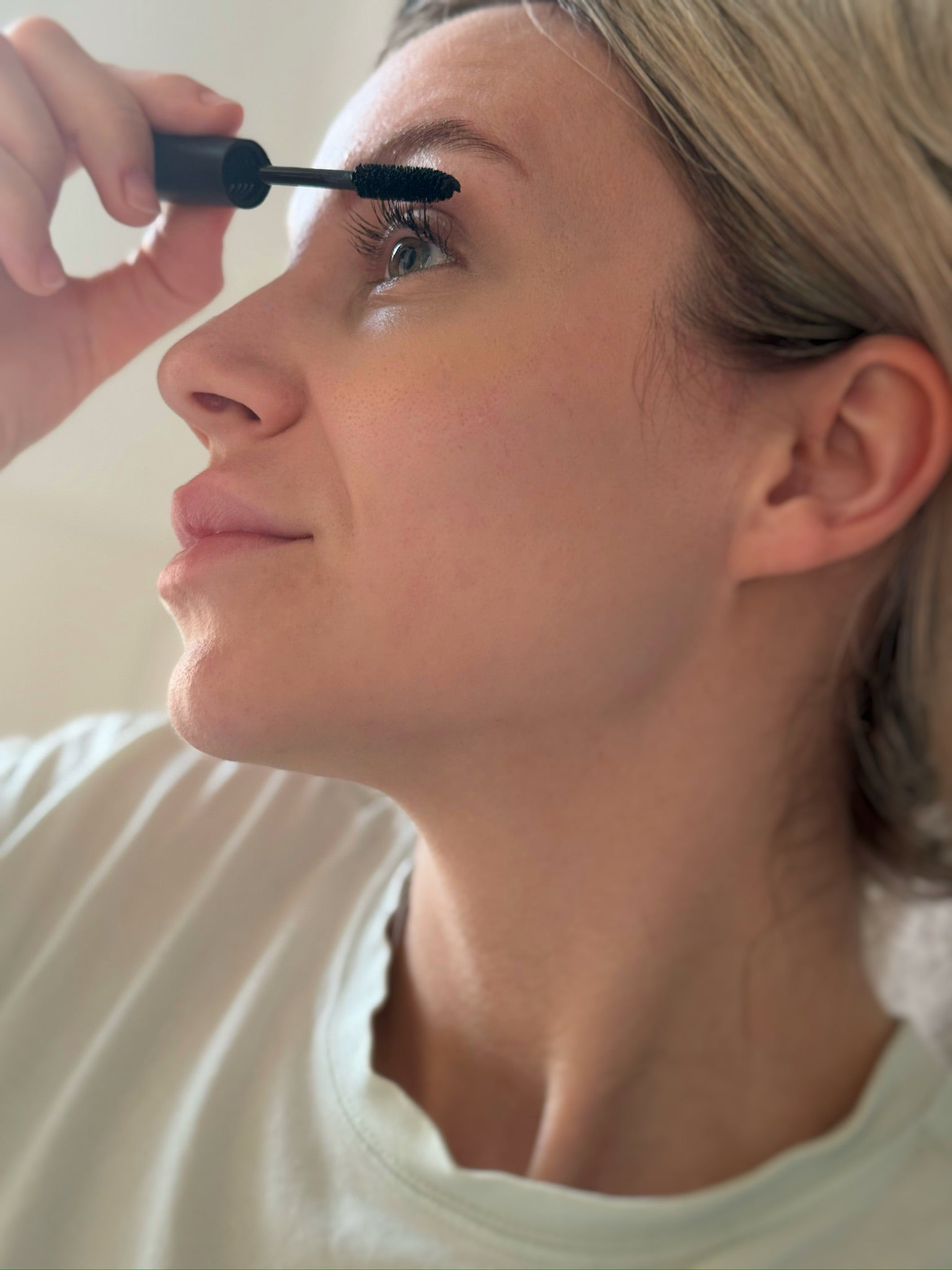 Junge Frau trägt Mascara auf