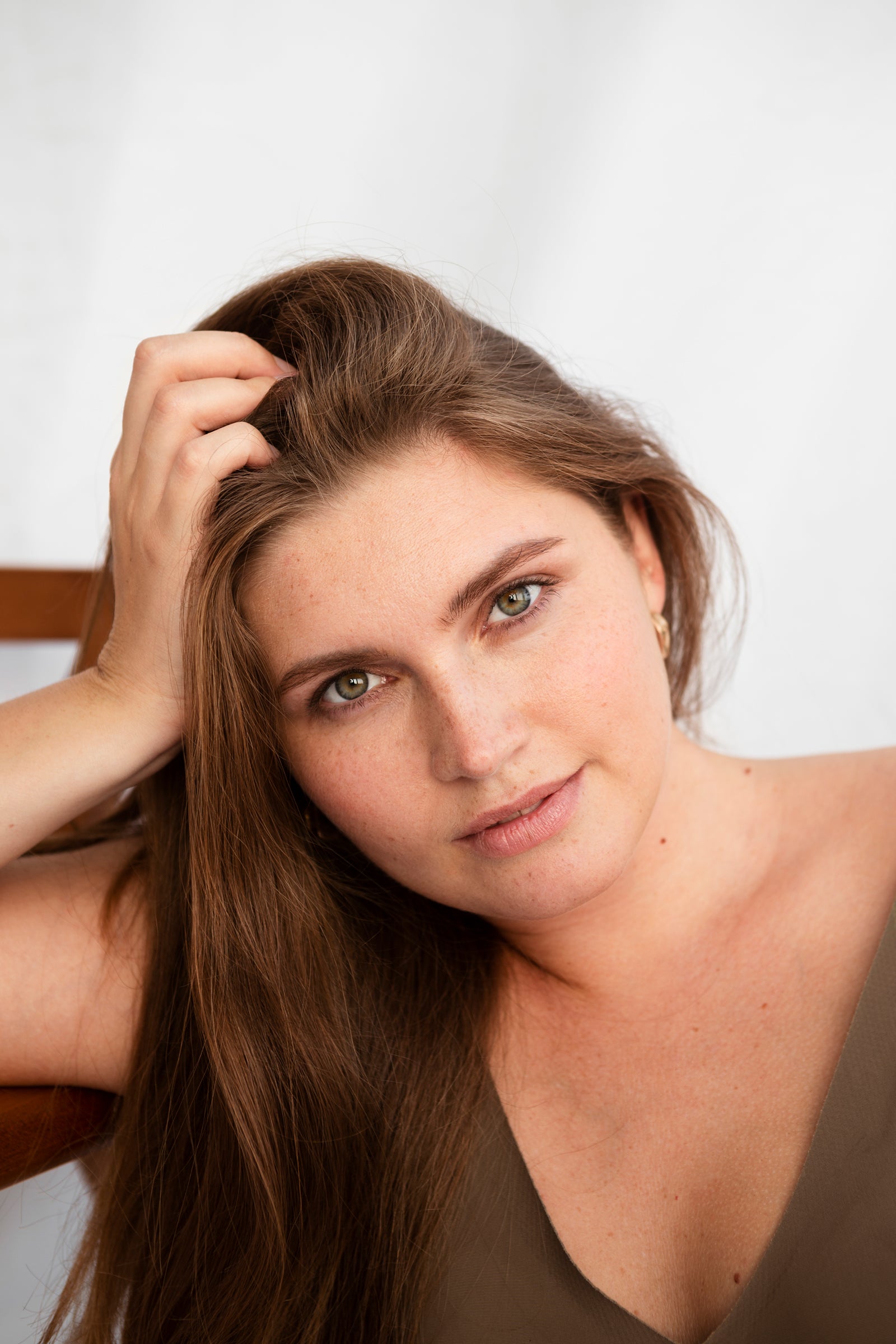Portrait einer jungen Frau mit gepflegter Gesichtshaut, vollem Haar und leichten Schatten unter den Augen.
