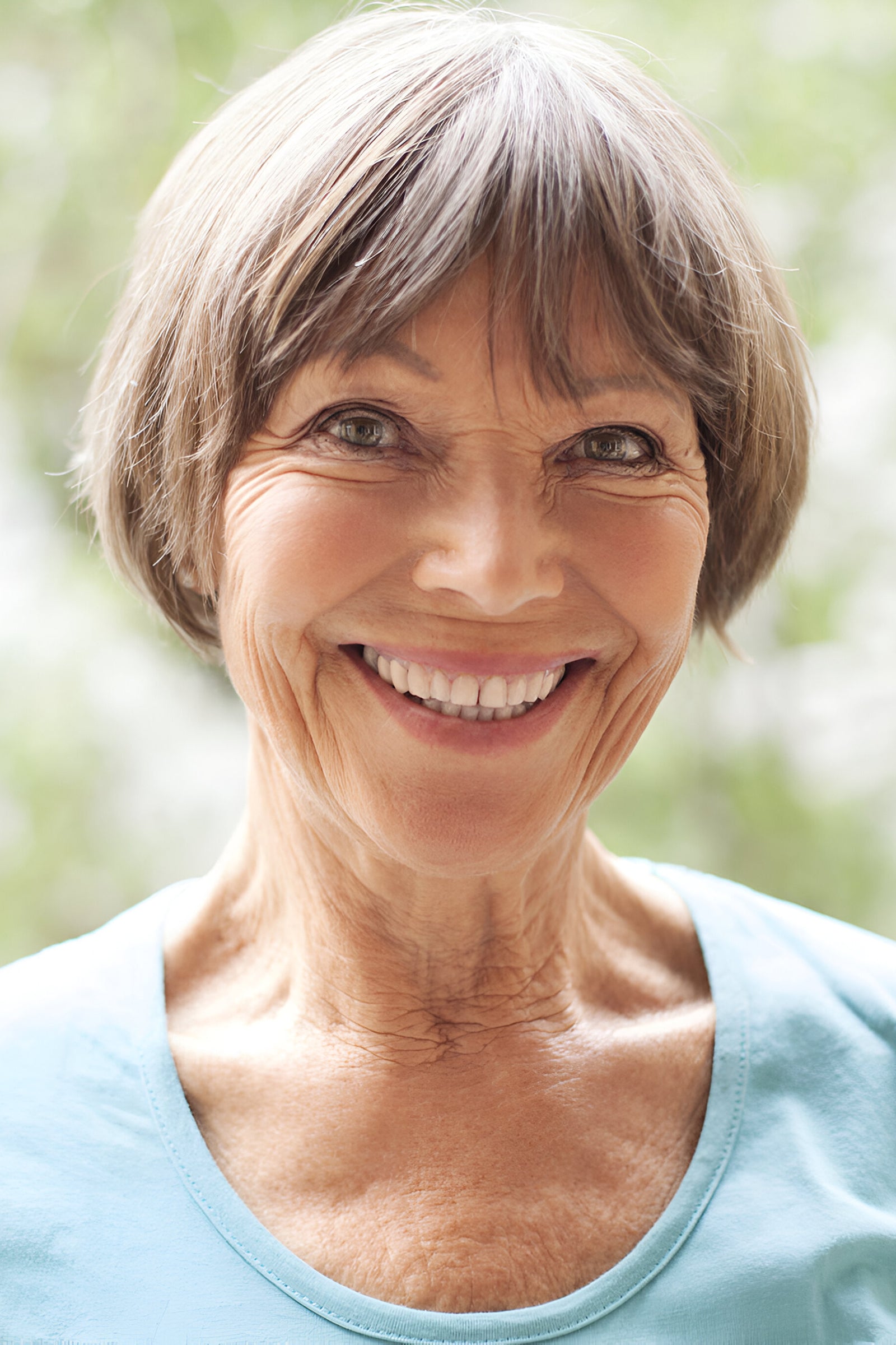 Portrait einer Frau mit reifer, gepflegter Gesichtshaut und deutlichen Falten um die Augen und den Mund.