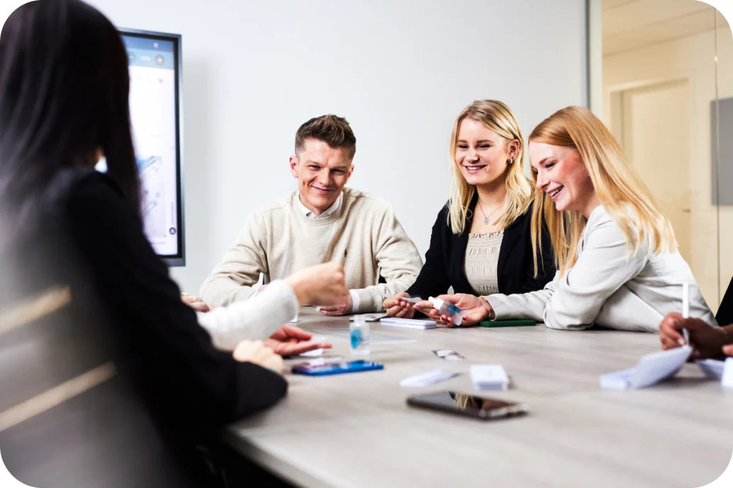 Team sitzt am Meetingtisch und bespricht Produkte von Dr. Massing Cosmetics